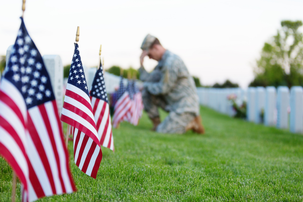 soldier kneeling at grave for Memorial Day