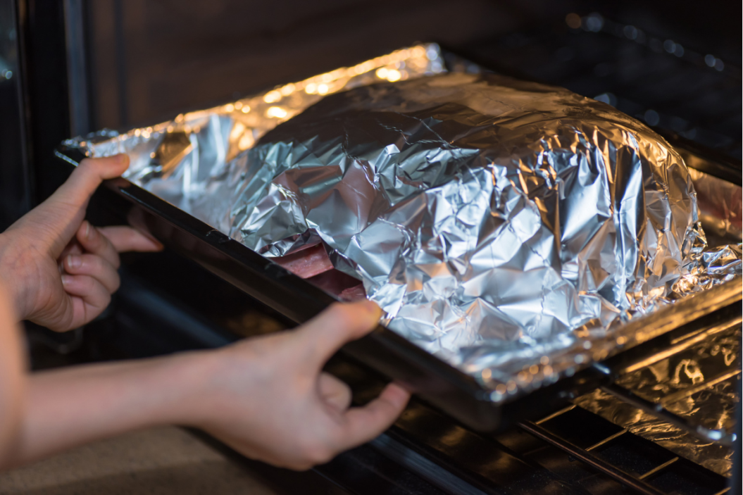 dish with aluminum foil in the oven
